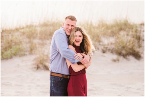 Couple hugging by dunes during Cocoa Beach Surprise Proposal