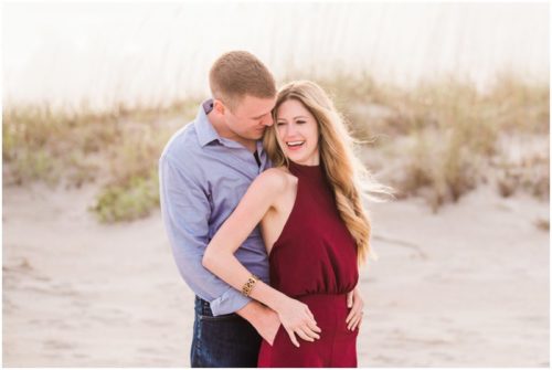 Couple hugging by dunes during Cocoa Beach Surprise Proposal