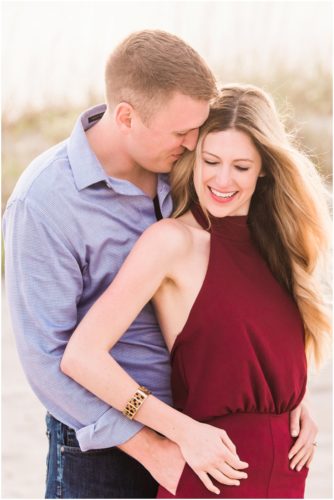 Couple hugging by dunes during Cocoa Beach Surprise Proposal