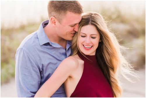 Couple hugging by dunes during Cocoa Beach Surprise Proposal