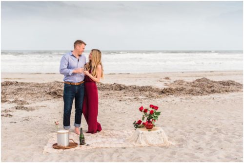 Couple toasting on beach after getting engaged during Cocoa Beach Surprise Proposal