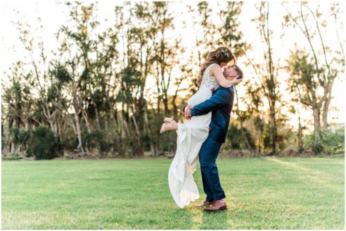 Groom lifting bride in air during Bellewood Plantation wedding, Vero Beach, Florida