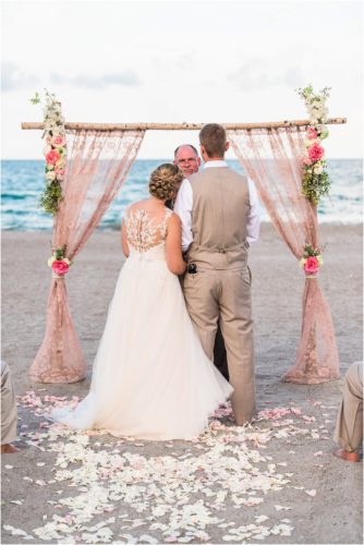 Bride and groom by the pink lace arch Cocoa Beach Wedding