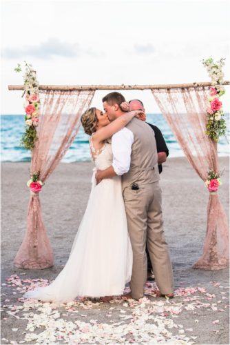 First kiss under pink lace arch Cocoa Beach Wedding