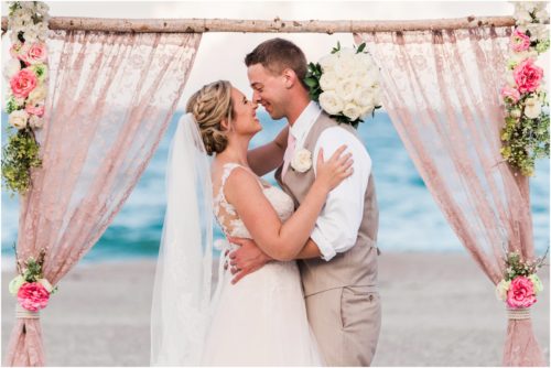 Bride and groom under beautiful pink arch Cocoa Beach Wedding