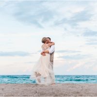 Groom spinning bride on beach Cocoa Beach Wedding
