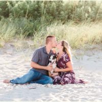 couple sitting on beach with dog Melbourne Florida engagement photographer