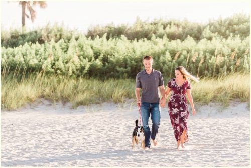 Couple walking with dog on beach Melbourne Florida engagement photographer
