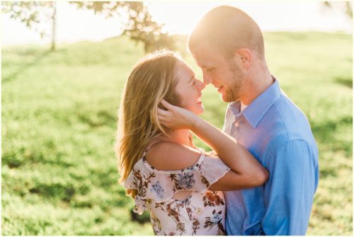 couple snuggling with glowing sun Melbourne Florida engagement photographer