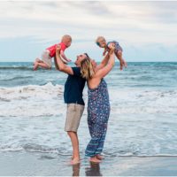 Family holding up kids during Family Beach Portraits in Melbourne Beach, Florida