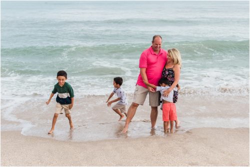 Grandkids hugging their grandparents near the water with Melbourne Beach Photographer Liz Cowie