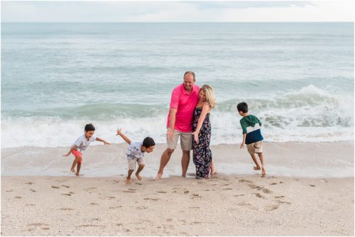 Grandkids hugging their grandparents near the water with Melbourne Beach Photographer Liz Cowie