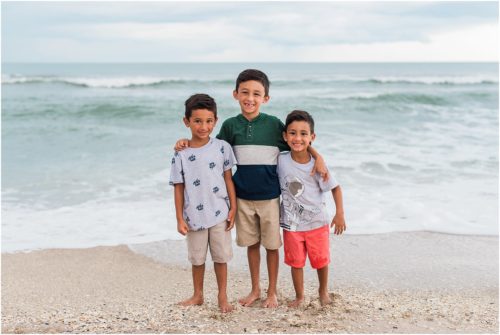 Three boys laughing by the edge of the water with Melbourne Beach Photographer Liz Cowie