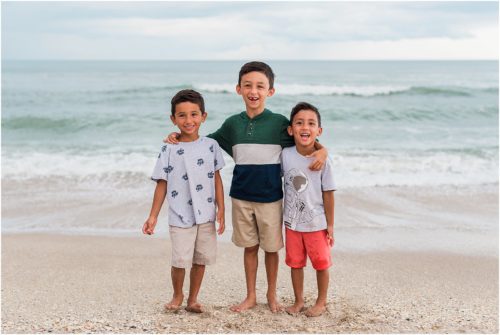 Three boys laughing by the edge of the water with Melbourne Beach Photographer Liz Cowie