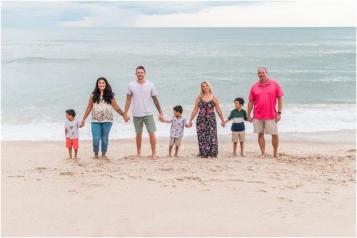 Entire extended family running on beach with Melbourne Beach Photographer Liz Cowie