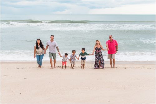 Entire extended family running on beach with Melbourne Beach Photographer Liz Cowie