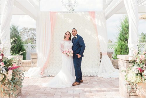 Bride and groom under arch at Grand Manor Wedding