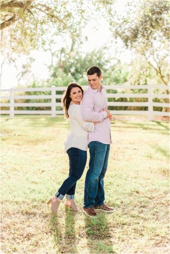 Couple hugging with white fence in bad ground during Up the Creek Farms Engagement photography