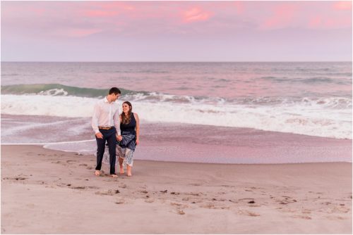 Couple with pink sunset on beach engagement photography