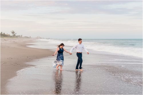 couple holding hands on beach engagement photography
