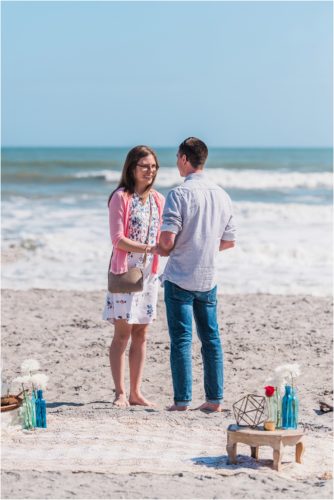 couple holding hands on beach during a Florida Beach Proposal