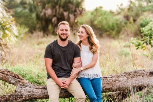 Couple sitting on log during Floridana Beach engagement