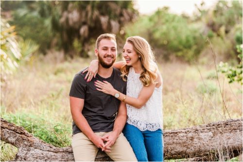 Couple sitting on log during Floridana Beach engagement
