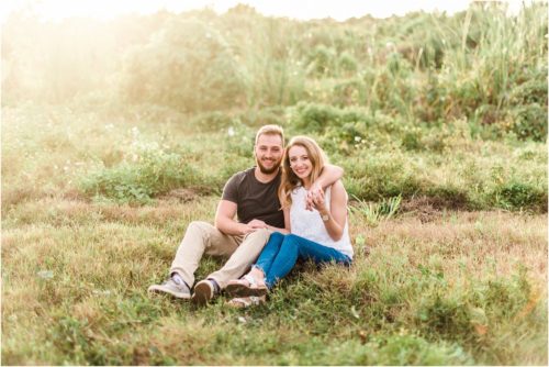 Couple cuddling in field during Floridana Beach engagement