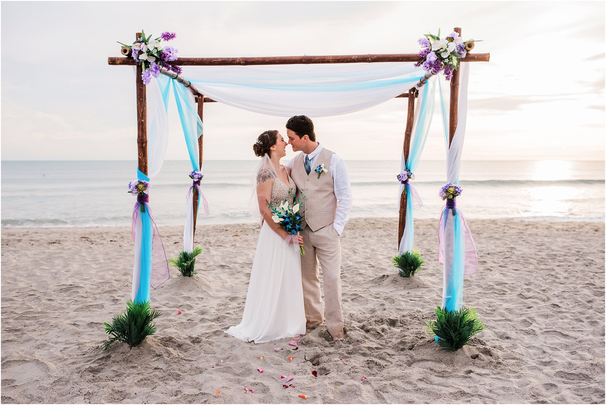 Bride and groom in front of arch during Cocoa Beach Sunrise Wedding