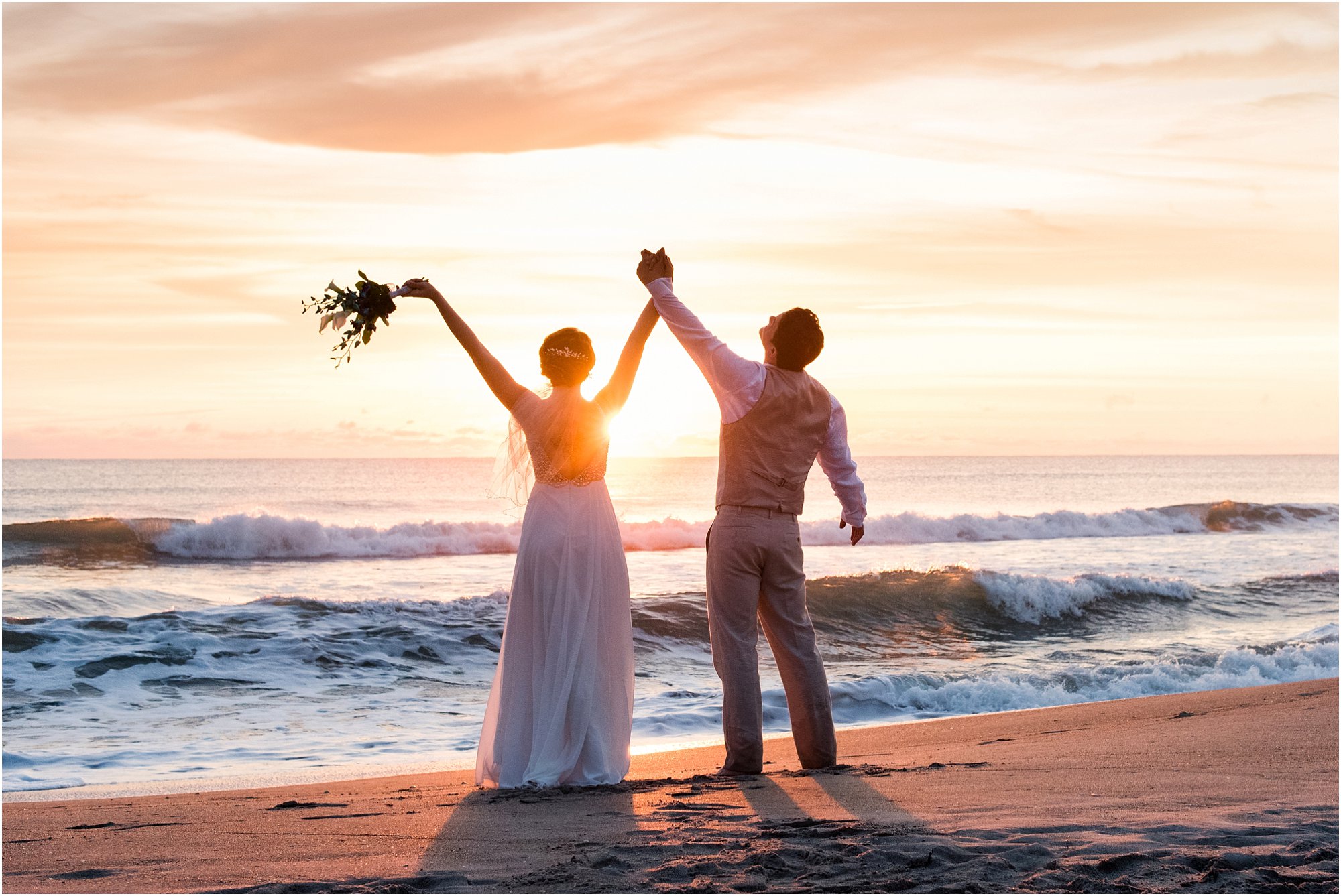 Bride and groom with arms in the air during Cocoa Beach Sunrise Wedding