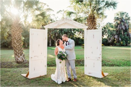 Couple together under white door frame arches at Banyan Estate Wedding