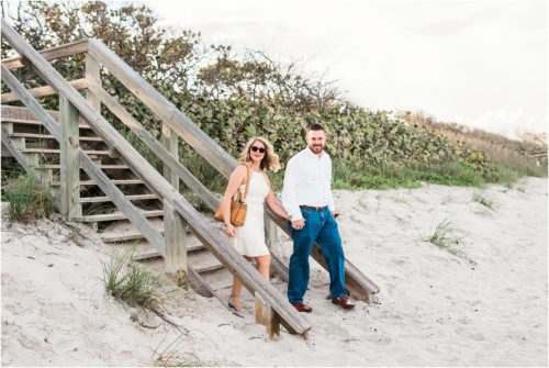 Couple walking down boardwalk onto the beach during Satellite beach proposal