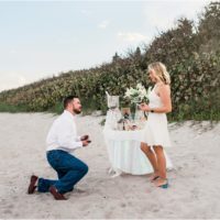 Man down on a knee asking his girlfriend to marry him during Satellite beach proposal