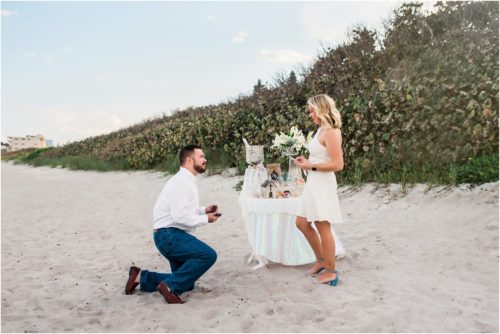 Man down on a knee asking his girlfriend to marry him during Satellite beach proposal