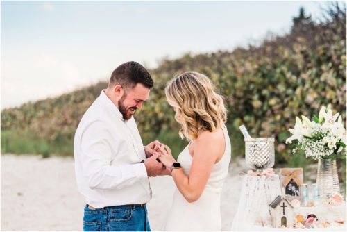 Man putting ring on girls finger after the proposal during Satellite beach proposal
