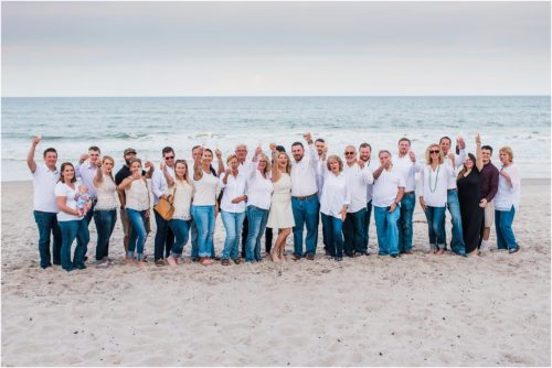 Newly engaged couple with entire group of family and friends during Surprise Proposal