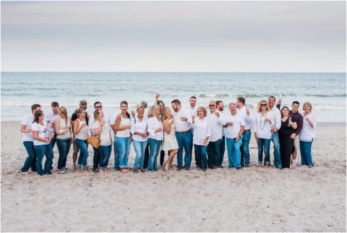 Newly engaged couple with entire group of family and friends during Surprise Proposal
