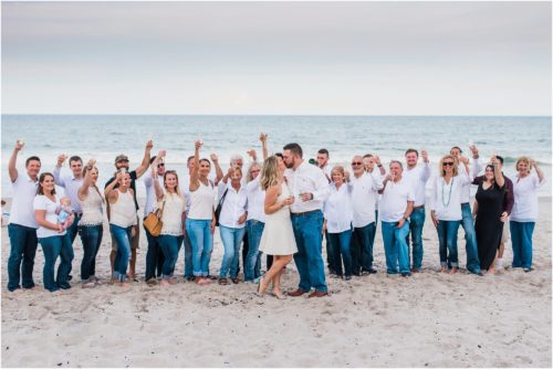 Newly engaged couple with entire group of family and friends during Surprise Proposal