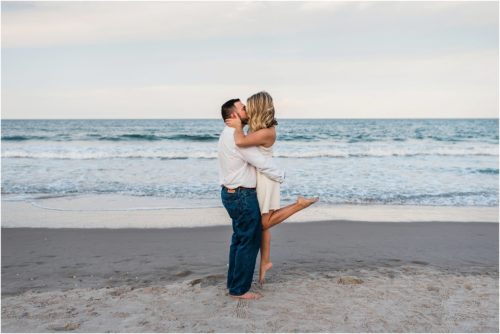 Man picking up girl on beach Satellite Beach Surprise Proposal
