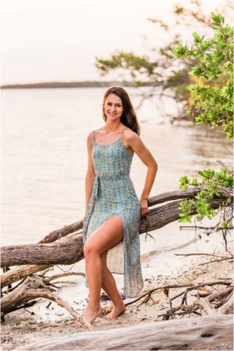 Girl in blue dress sitting on driftwood Melbourne Beach Senior Photography