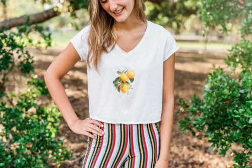 lemon t-shirt on girl standing by oak trees Riverside Park Senior Portraits