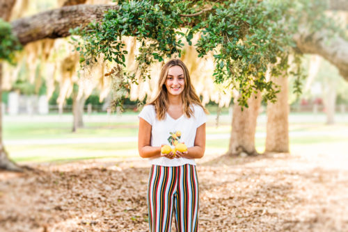 Girl with lemon on her shirt holding lemons