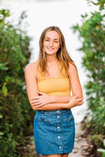 Girl in yellow top with arms crossed