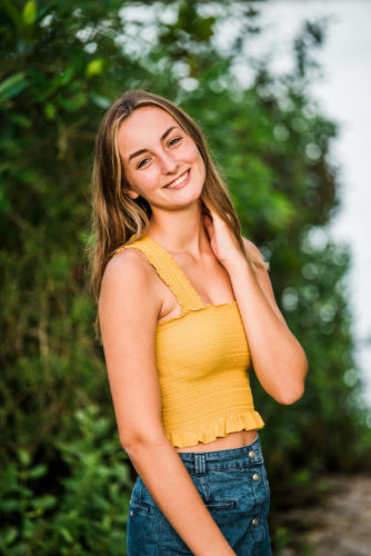 Girl in yellow top by trees