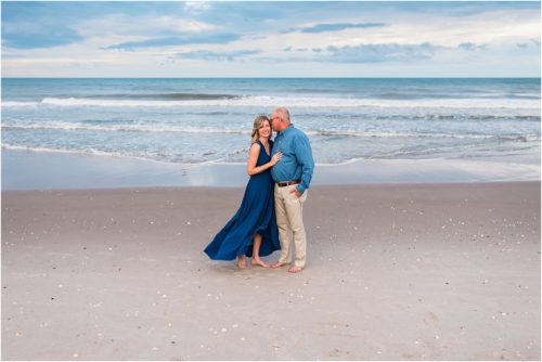 Couple hugging on beach both wearing blue