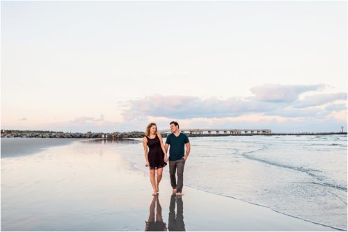 Couple holding hands with Jetty in background Best Engagement Session Beach Locations