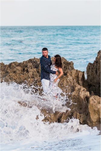 Couple on rocks at house of refuge engagement session featured as Best Engagement Session Beach Locations
