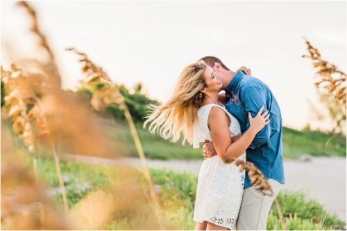 Couple kissing by sea oats in Vero Beach featured as Best Engagement Session Beach Locations