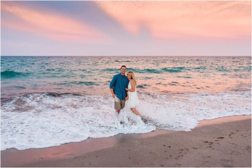 Couple standing in waves during Vero Beach engagement session
