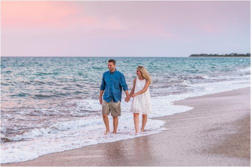 couple walking along ocean in Vero Beach with sun setting